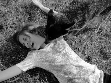 dog kissing girl, dog licking girl, girl laughing, girl with dog, girl playing with dog